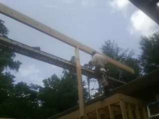 Carpenter setting a ridge beam over a new addition frame — Ice Dam Removal by Roofing Brothers in Shermans Dale