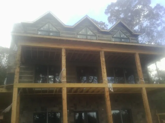 Dormers and porch framing on a large log home under construction — Roof Coating work by our crew in Shermans Dale