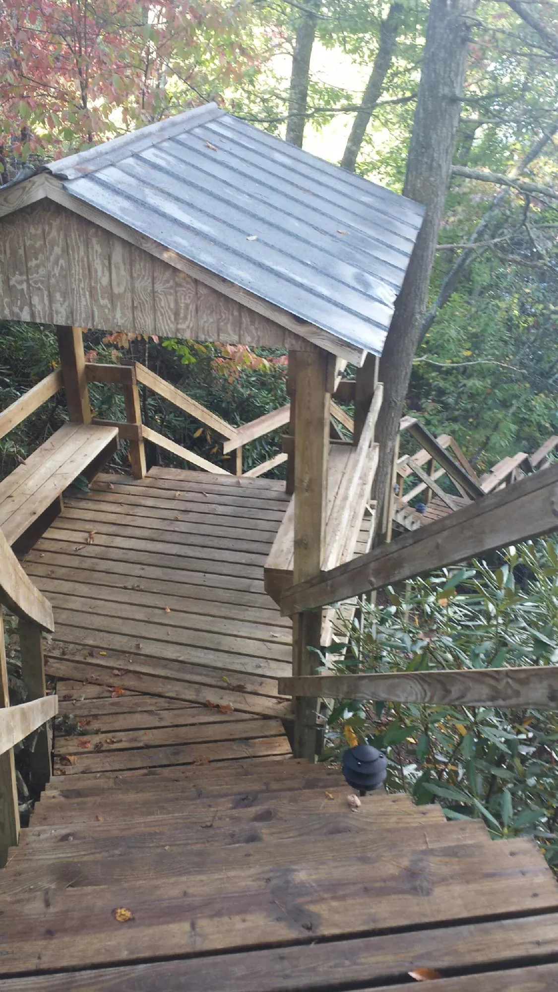 Metal roofed shelter over wooden steps on a wooded walkway — Skylight Repair & Installation work by our crew in Shermans Dale